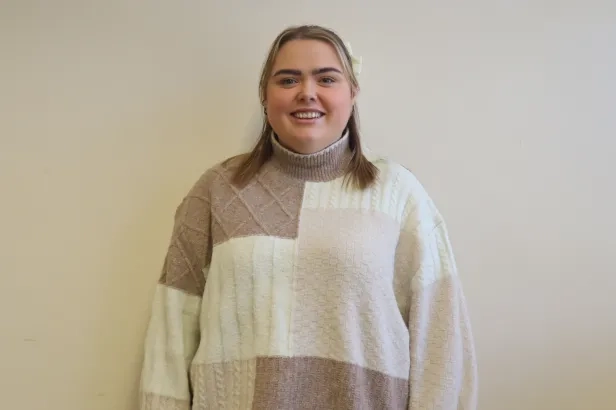 Youg woman in business casual smiling.