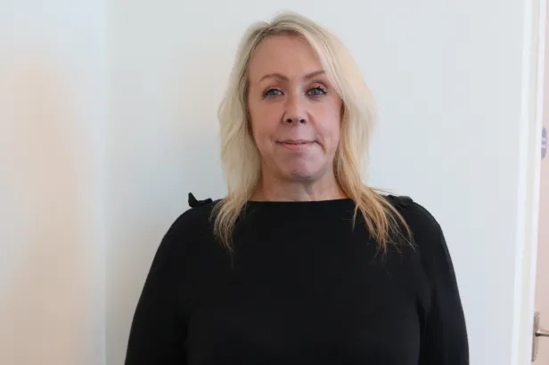 Youg woman in business casual smiling.