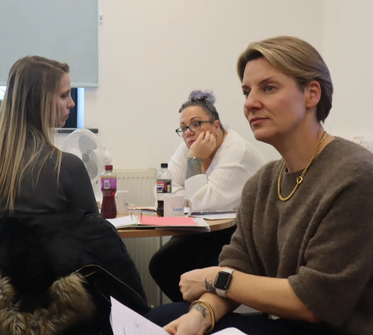 LEAD programme trainer explaining task as three participants on the programme look on smiling