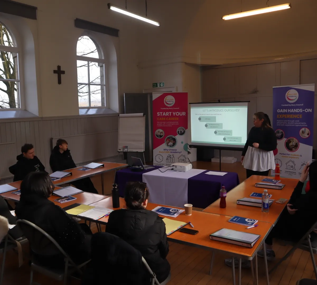 Wide angle shot of two members of the Bury Care Academy team introducing the Young People