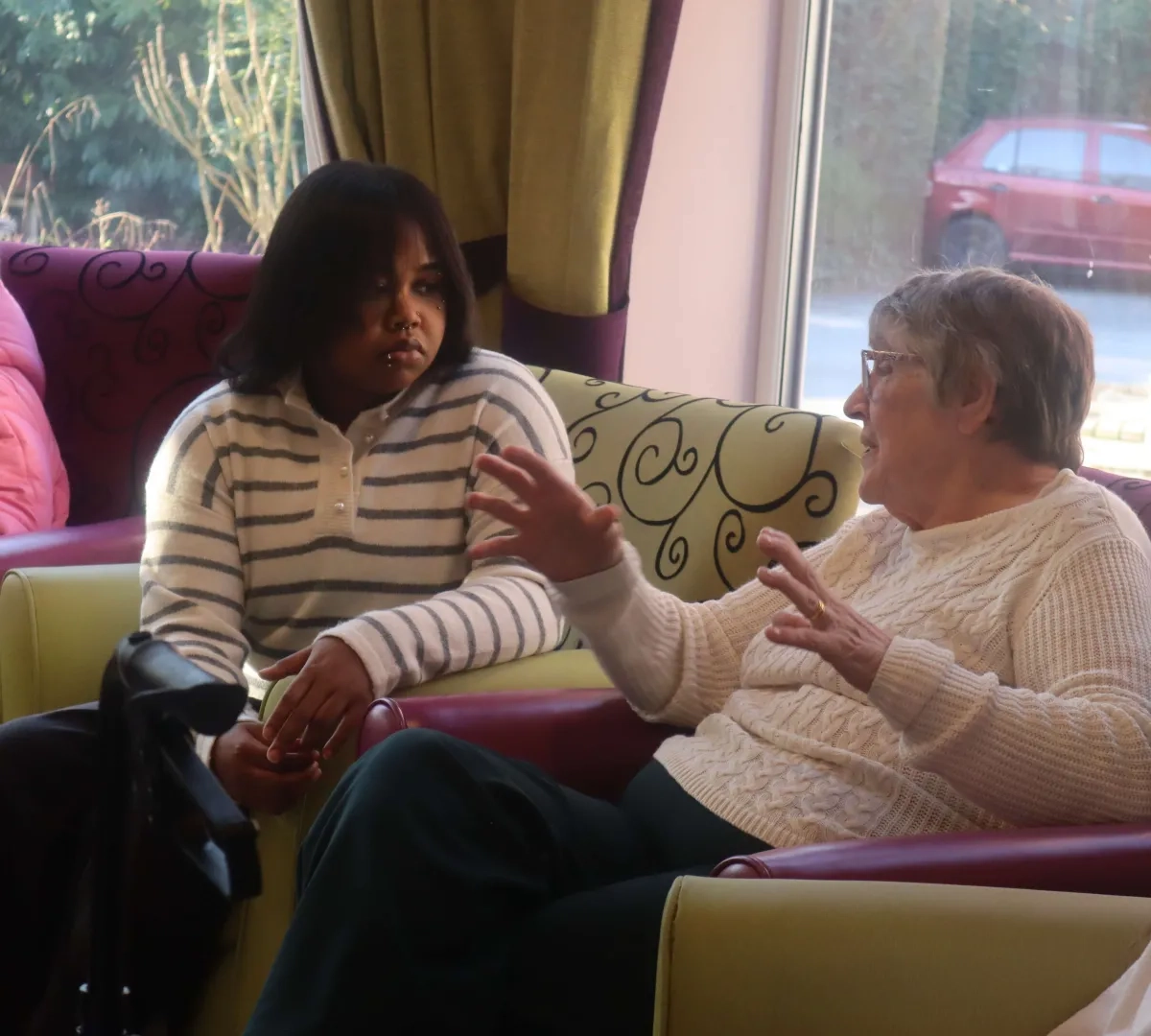 student placement sat talking to elderly resident in care home