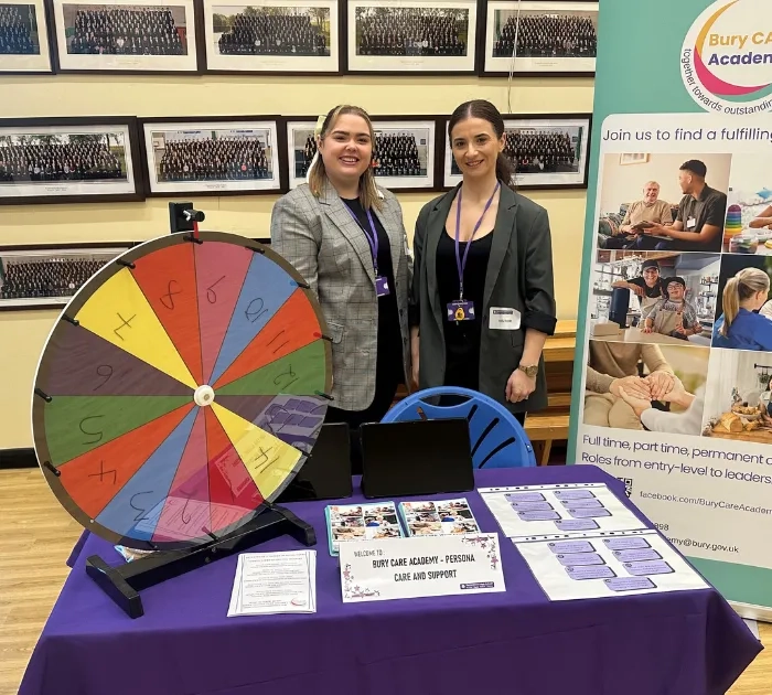 Bury Care Academy staff members pictured smiling at the Parrenthorn Year 9 and 10 Careers fair