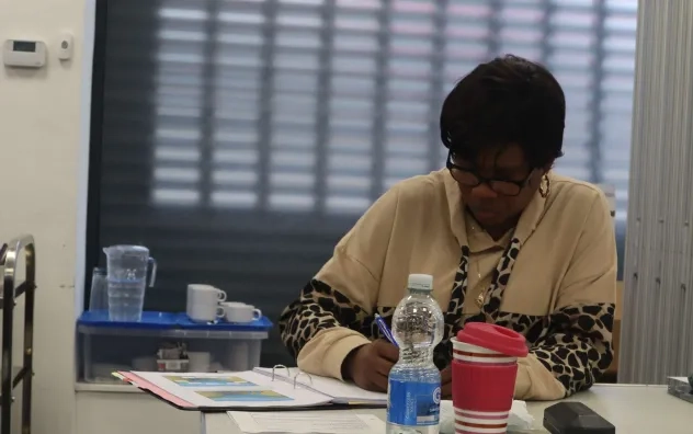 Image shows participant on the programme writing down in a textbook