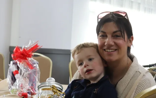 a woman is pictured with a child on her lap holding a jar of sweets
