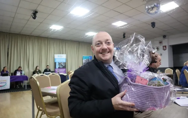 Attendee is pictured smiling holding a gift basket at the Digital Skills Event