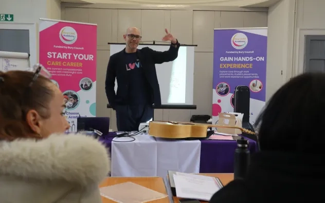 Guest speaker from the Art of Brilliance gestures to our attendees while they look on